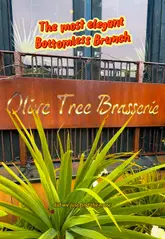 A couple reviews a bottomless brunch at Olive Tree Brasserie in Lytham, showcasing the elegant interior, the menu, and a variety of small plates and cocktails.