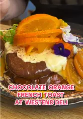 A vlog-style review of West End Deli in Glasgow, featuring two creators enjoying a breakfast/brunch meal. The video highlights the chocolate orange French toast and a full breakfast, while also showing the cafe's interior and exterior.