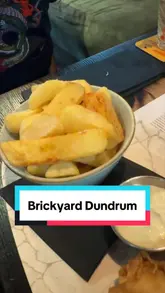 The video is a first-person review of Brickyard, a gastropub in Dundrum. The creator walks through the beer selection, showing the menu board and a beer flight, followed by a montage of various dishes including nachos, mac and cheese bites, wings, a burger, steak, and fish and chips. The creator provides commentary on the quality of the food and the beer selection.