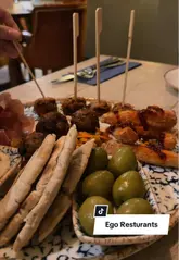 A montage of a meal at Ego Mediterranean, featuring a mezze platter, pasta, halloumi salad, coffee, and desserts, showcasing the restaurant's interior and food offerings.