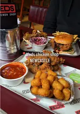 A review-style video showcasing a visit to Feds Chicken Shop, highlighting the menu deals, interior, and various food items like fried chicken, burgers, and sides.