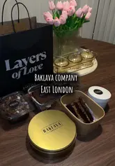 A promotional video for 'Layers of Love' in East London, showcasing their range of desserts including baklava, mini egg crunch cake, and tiramisu. The video features shots of the shop's interior and close-ups of the desserts being served.