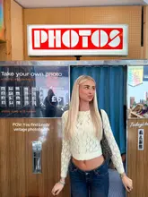 A portrait of a young woman standing in front of a vintage-style photo booth in Leeds, with text overlay indicating the location and price. The image serves as a promotional post for the activity.