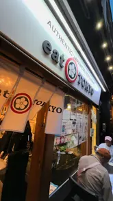 A couple visits Eat Tokyo, a Japanese restaurant, to review their experience. They show the exterior, the menu, various dishes including sushi, katsu curry, and dumplings, and share their thoughts on the food.
