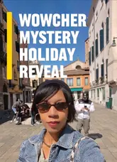 Happy traveler revealing their £99 Wowcher mystery holiday destination for a travel review.