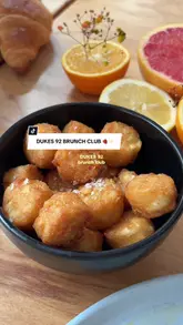A creator visits Dukes 92 in Manchester to review their new brunch club offering. The video features shots of the venue's interior and outdoor seating, the brunch menu, coffee, cocktails, and food items like poached eggs on focaccia and a fruit and pastry platter.