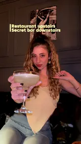 A creator visits a Pan-Asian restaurant and a hidden bar in Chiswick, showcasing the food, cocktails, and interior atmosphere. The video follows a clear structure, moving from the restaurant upstairs to the secret bar downstairs, highlighting the venue's suitability for a date night.