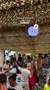 A fast-paced, energetic montage showcasing a visit to La Guérite beach club in Cannes. The video captures the journey by boat, the scenic island location, the dining experience, and the transition into a lively party atmosphere with table dancing and music.