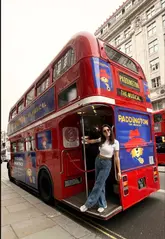 The video features a creator enjoying a Paddington-themed afternoon tea experience on a double-decker bus in London. The footage includes shots of the bus interior, the themed food items like marmalade sandwiches and cupcakes, and views of the city, set to music.