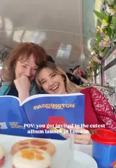 A vlog-style video showcasing an album launch event for 'Paddington: The Musical' held on a themed London bus, featuring afternoon tea and a scenic tour of the city.