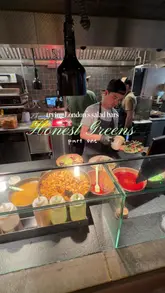 A short, handheld vlog-style review of Honest Greens in London, showcasing the exterior, menu, interior, drink station, and a plated meal.