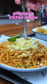 A vlog-style review of a vegan Italian pop-up kitchen located in a food hall. The creator samples three dishes—walnut bolognese, pesto arancini, and Biscoff tiramisu—providing honest feedback on flavor, texture, and value while showcasing the menu and the venue's casual atmosphere.