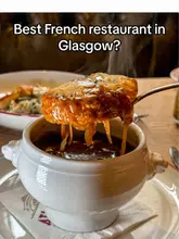 A review of Atlantic Bar & Brasserie in Glasgow, featuring the restaurant's French cuisine, live jazz music, and elegant interior. The video highlights several dishes including French onion soup, scallops, beef shin, sirloin steak, and desserts like rum baba and chocolate marquise.