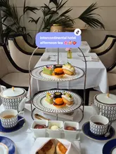 A polished, aesthetic montage showcasing an afternoon tea service at the InterContinental Park Lane. The video features close-ups of the tiered food stand, tea pouring, and the table setting, highlighting the presentation of the sandwiches, scones, and desserts.