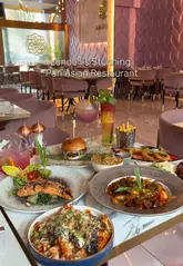 A promotional video for Enigma, a Pan-Asian restaurant in Ilford, featuring a montage of the venue's interior, various dishes including steak, prawn noodles, and cocktails, and a focus on the dining experience.