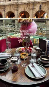 A short, aesthetic montage showcasing a cherry blossom-themed afternoon tea service at a venue in the Royal Exchange. The video features close-up shots of the tea stand, champagne pouring, and tea service, highlighting the presentation of the food and the elegant setting.