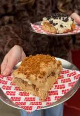 Two creators visit 'Rise & Bun' in Margate to review their viral cinnamon rolls. They sample several different flavors, including the original, lemon and blueberry, pistachio, coffee latte Oreo, Biscoff, and hazelnut cream, providing their feedback on the taste and texture.