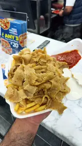 A creator visits a local takeaway shop in Wibsey, Bradford, to review their pizza, burger, and donner meat and chips, highlighting the family-run nature of the business.