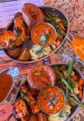 A short, polished video showcasing a unique Indian-inspired Sunday roast at Tuk Tuk in Edinburgh. The reel features close-up shots of the roast dinner, including gravy being poured, alongside other menu items like okra fries and pani puri. It concludes with a brief look at the restaurant's interior and exterior.