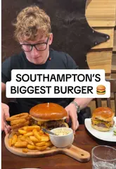 A creator attempts a 1kg burger challenge at Argento Steak House in Southampton, documenting the process from signing a waiver to eating the meal.