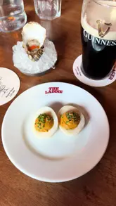 The creator visits The Highland Laddie in Leeds, providing a review of the pub's atmosphere, menu, and specific dishes including vindaloo deviled eggs, a Highland beef burger, and an arctic roll. The video features the creator's commentary on the food and drink, offering a personal perspective on the experience.