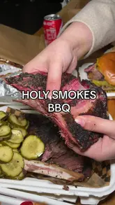 A fast-paced review of Holy Smokes BBQ, featuring close-ups of tender smoked brisket, short rib, loaded fries, and smash burgers. The video highlights the preparation process and the final product, with the creator providing a voiceover review of the food quality and texture.