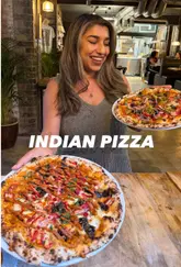 A promotional reel for East West Pizza, highlighting their Indian-fusion pizza menu, including butter chicken, chicken tikka, and lamb keema options, alongside starters like masala lobster arancini and crispy corn chilli chaat.