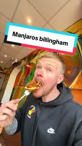 A food review video featuring a creator visiting Manjaros in Billingham. The video showcases the restaurant's interior and several dishes, including a hotshot parmo, tandoori pizza, and rasta pasta, with the creator providing commentary and taste tests.