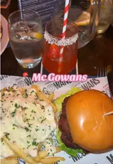 A fast-paced montage showcasing the food, cocktails, and lively atmosphere at McGowans, featuring shots of burgers, fries, fish, and the venue's interior.