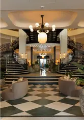 A high-quality, cinematic montage showcasing the interiors, dining areas, and food offerings of a new luxury hotel in London. The video features slow, sweeping shots of the lobby, restaurant, and garden, alongside close-ups of pastries and plated dishes.