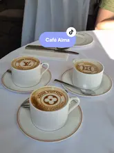 A short, aesthetic montage showcasing the interior, branding, and menu items at the Louis Vuitton hotel pop-up cafe in London. The video focuses on the visual details of the coffee and cake, as well as the elegant table settings and decor.