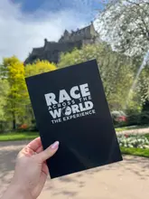 A group of friends participates in an interactive 'Race Across the World' themed experience in Edinburgh, solving puzzles and navigating the city, with a brief stop for a brownie.