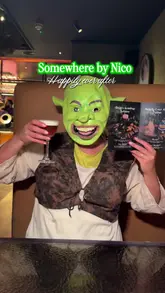 A promotional video for a Shrek-themed cocktail experience at 'Somewhere by Nico', featuring creators dressed as Shrek and Fiona, showcasing the themed drinks and a live performance by a Fairy Godmother character.