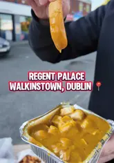 A food review video featuring a creator trying various dishes from a Chinese takeaway called Regent Palace in Walkinstown, Dublin. The creator samples a spicy bag, ribs, and chicken curry, providing commentary on the quality and taste of the food.