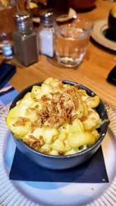 A group of friends visits 'Church on the Hill' in Glasgow, showcasing a variety of sharing dishes including Detroit-style pepperoni pizza, ranch chicken tenders, baked mozzarella, chips, and mac and cheese, alongside a selection of cocktails.