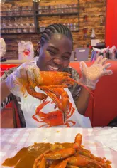 A creator visits Crabbish in Liverpool to try their seafood boil. The video features the creator wearing a bib and using tools to eat a large platter of lobster, crab, prawns, corn, and potatoes, highlighting the interactive and fun nature of the dining experience.