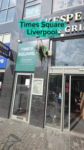 A video tour of Times Square in Liverpool, highlighting its breakfast menu, spacious interior, large sports screen, and city views. The creator reviews the Full English breakfast and mentions the venue's suitability for groups and private events.