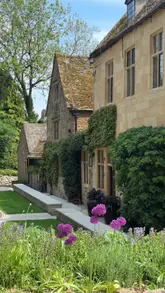 A cinematic montage showcasing a stay at a picturesque hotel in the Cotswolds, featuring exterior architecture, cozy interior spaces, and dining experiences.