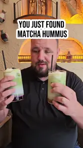 A review of 'The Queen's Cup' in Withington, Manchester, featuring a variety of Middle Eastern and Turkish-inspired dishes and drinks, including unique items like matcha hummus and tiramisu lattes. The video highlights the cozy interior and the diverse menu options available for breakfast and brunch.