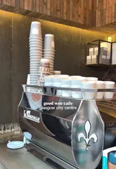 A short, handheld-style video showcasing Laboratorio Espresso in Glasgow city centre. The video features quick cuts of the coffee machine, menu board, cake display, interior seating, and a close-up of a slice of carrot cake being eaten, ending with a shot of the exterior.
