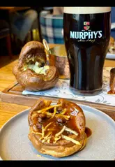 A couple visits Element in Edinburgh for a Sunday roast, showcasing the venue's cozy atmosphere, drinks, and a variety of dishes including stuffed Yorkshire puddings, beef sirloin, mushroom Wellington, and desserts.