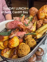 A short, engaging video showcasing a Sunday roast platter at Aura in Cardiff. The reel features close-ups of the food, a gravy pour, a cocktail, and shots of the restaurant interior, providing a good overview of the dining experience.