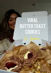 A creator visits a pop-up bakery on Portobello Road to try viral buttered toast cookies, banana pudding, and specialty coffee. The video features close-ups of the food, the venue interior, and the creator's reactions.