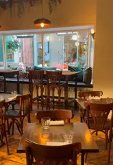 A creator visits Queens Wine Bar and Bistro in Liverpool, showcasing the food and drinks while promoting the EatClub app for discounts.