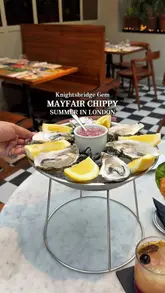 A short, punchy montage featuring a variety of seafood dishes, including oysters, a lobster roll, and classic fish and chips, served in a stylish, plant-filled restaurant setting in Knightsbridge. The video uses quick cuts and close-up shots to emphasize the quality and presentation of the food.