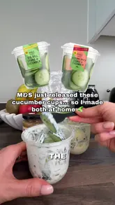 A concise recipe tutorial demonstrating how to make two different dressings for a cucumber snack, inspired by M&S products. The video uses top-down, well-lit shots to show the mixing process and final assembly.