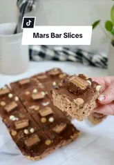 A concise, top-down recipe tutorial demonstrating how to make Mars Bar slices using five ingredients. The video follows a standard cooking format with clear steps from melting the ingredients to setting the final product.