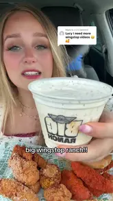 A creator reviews Wingstop food items, specifically focusing on the new large ranch dip, while sitting in a car. The video features close-ups of various menu items like tenders, a burger, fries, and corn being dipped and eaten.