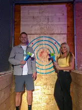A montage-style promotional video for Boom Battle Bar, showcasing various competitive socialising activities like axe throwing, augmented reality darts, and shuffleboard, alongside shots of cocktails and bar snacks.