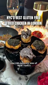 The video features a creator reviewing a pop-up collaboration between Coqodaq and Lucky Cat Mayfair in London. It showcases signature dishes like caviar and truffle-topped fried chicken, tuna tartare, and sushi, while highlighting the venue's gluten-free friendly options and upscale atmosphere.